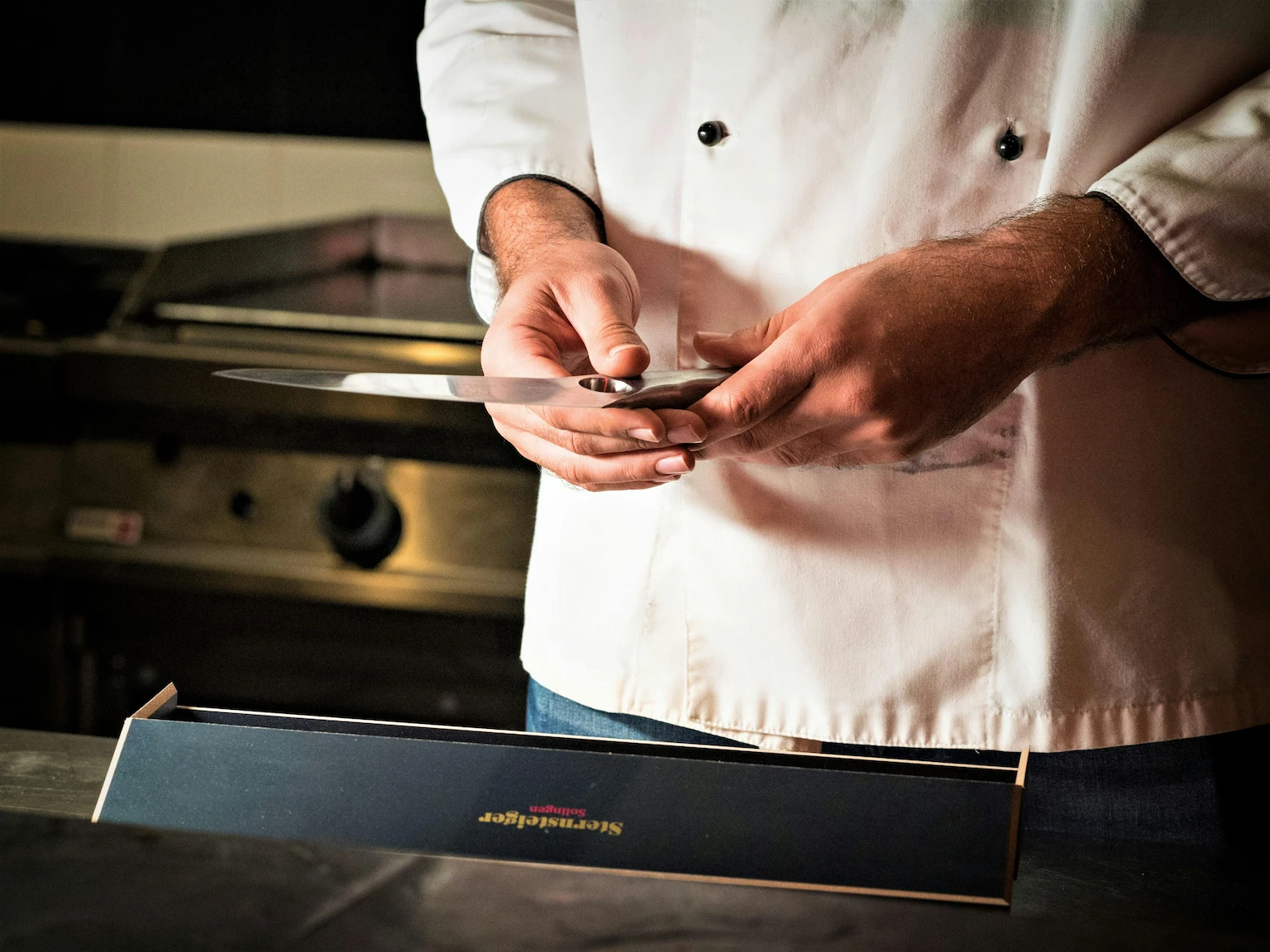Professional Michelin-trained chef precisely plating gourmet dish in luxury kitchen for exclusive private event