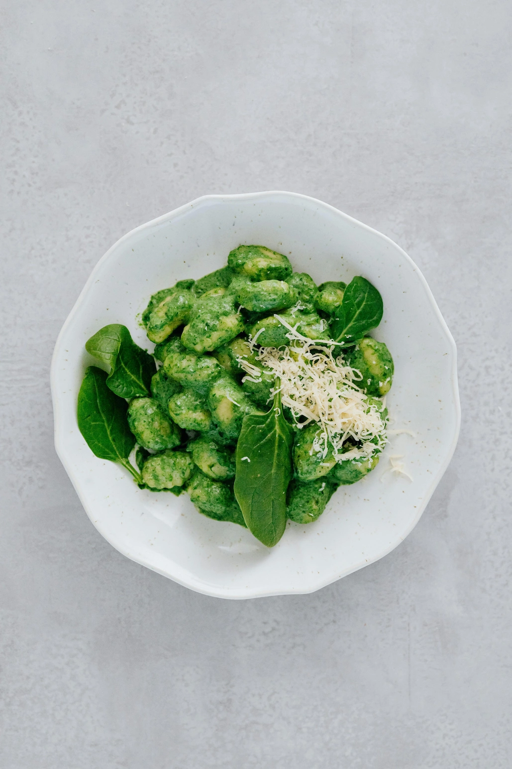 Vegan spinach gnocchi with fresh greens and plant-based parmesan & horseradish gratted, crafted by a private plant-based chef.