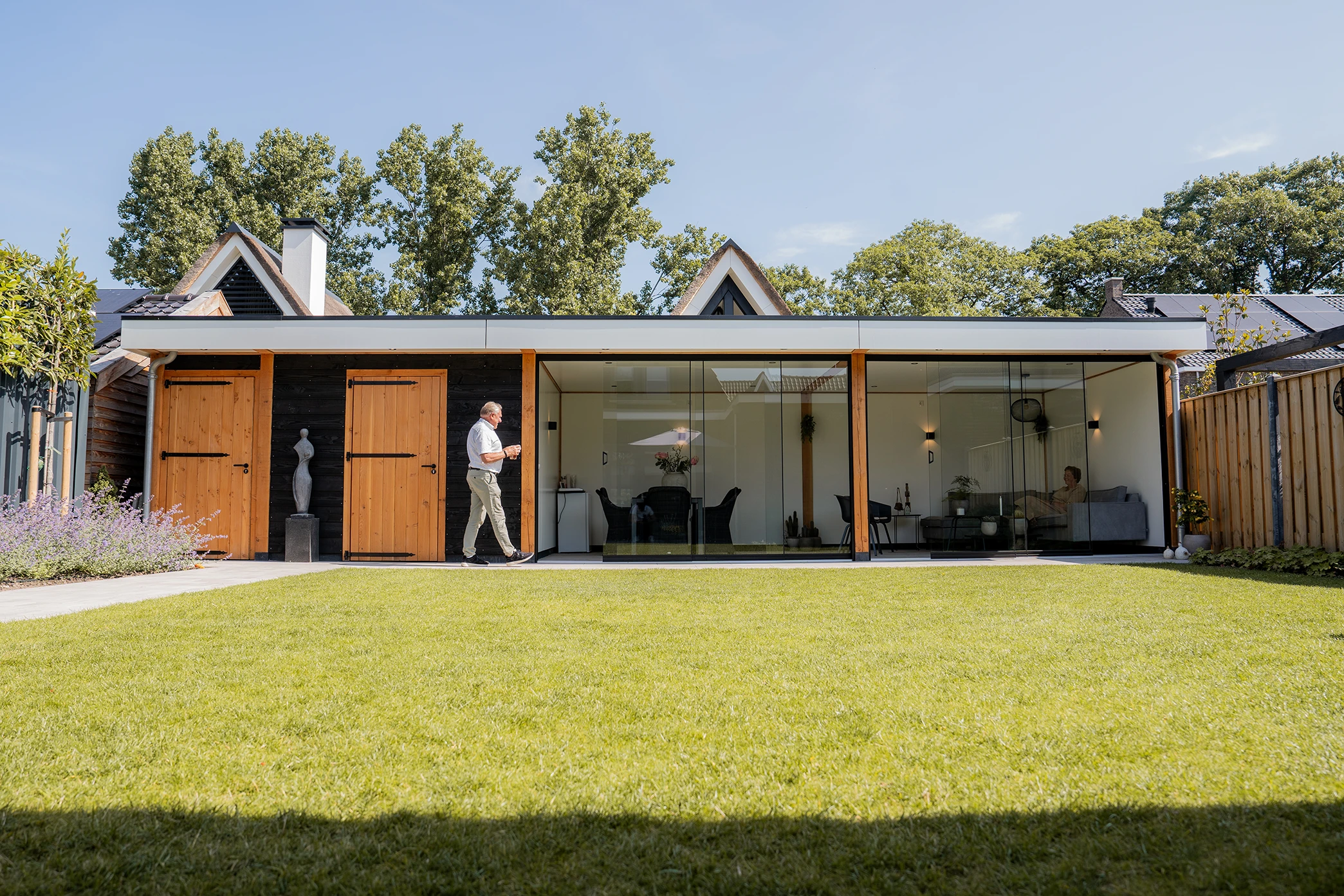 Douglas overkapping met glazen wanden met bewoners in achtertuin