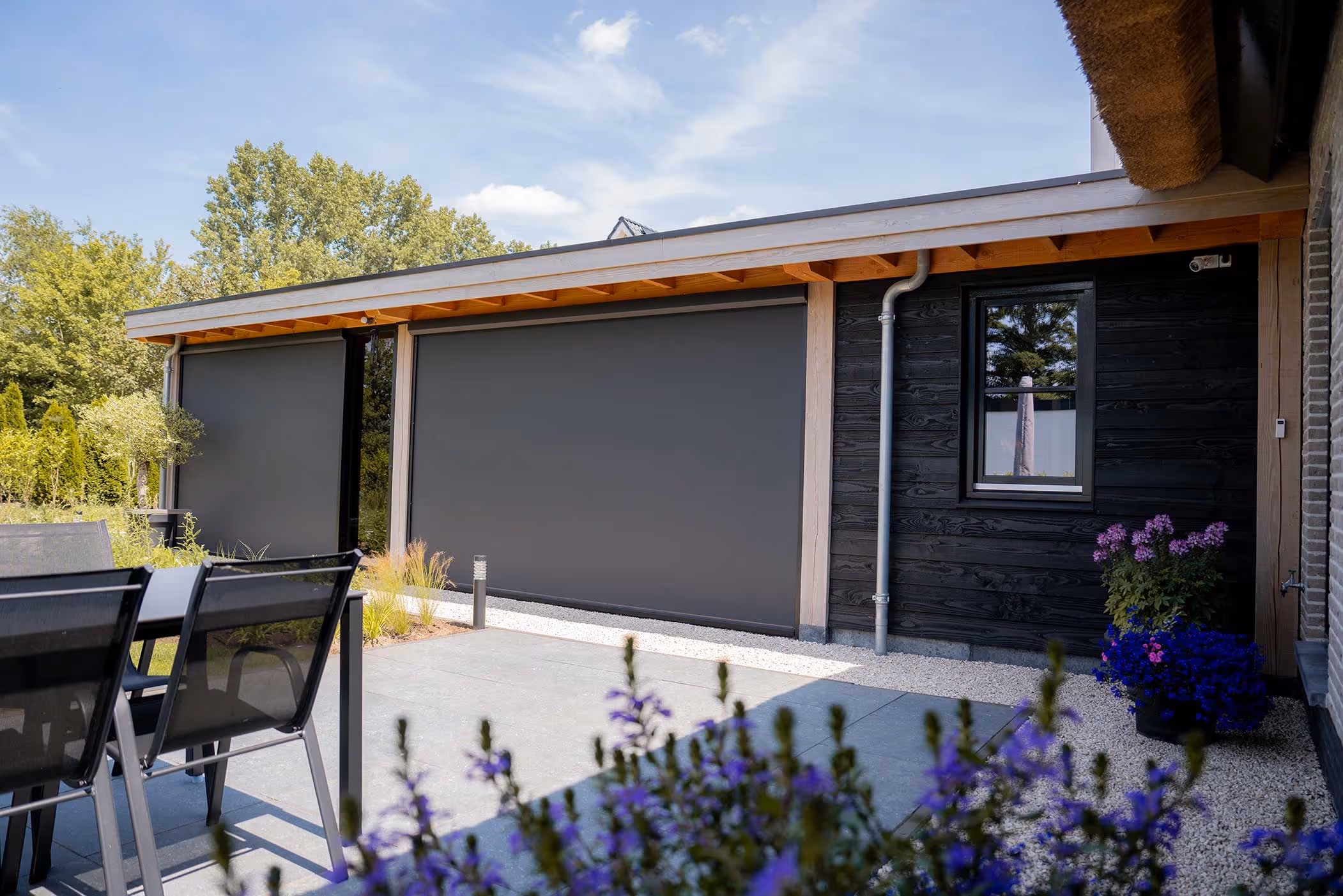 Douglas schuur met fietsenberging in het zwart in een achtertuin met raam