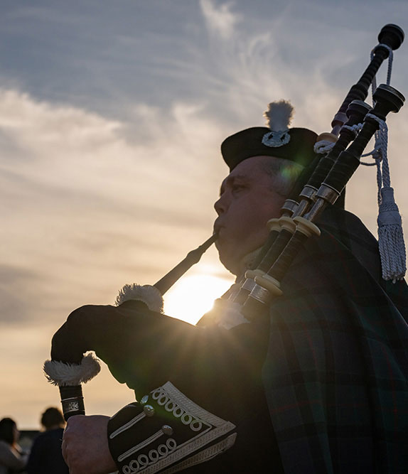 Piper playing in a sunlit background at the Club House St Andrews
