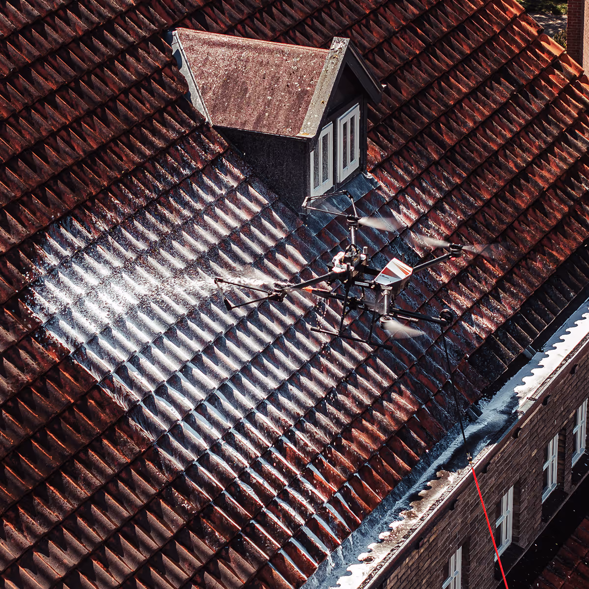 Drone wast een rode dak met sproeiers boven het dakraam.