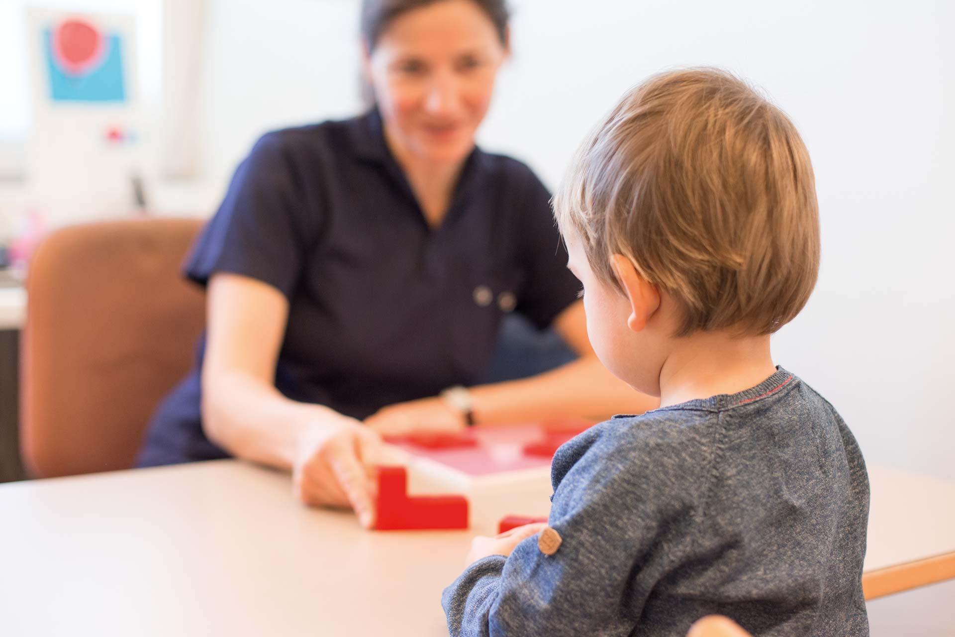 Krankenschwester spielt mit kleinem Jungen.