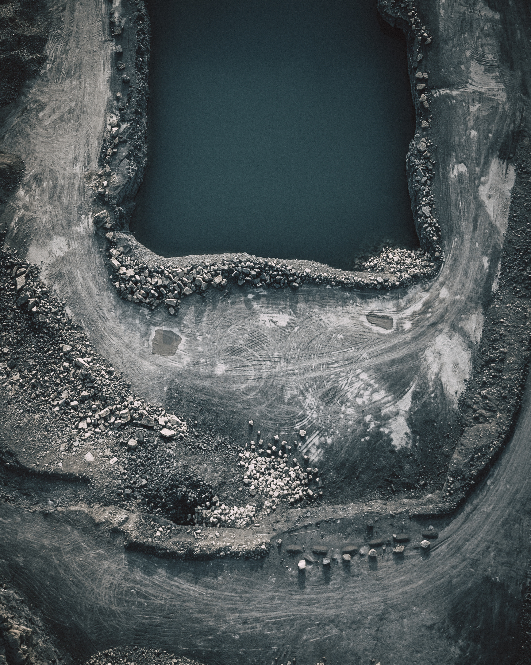 Panoramic view of an open-pit mine with drilling rigs in operation.