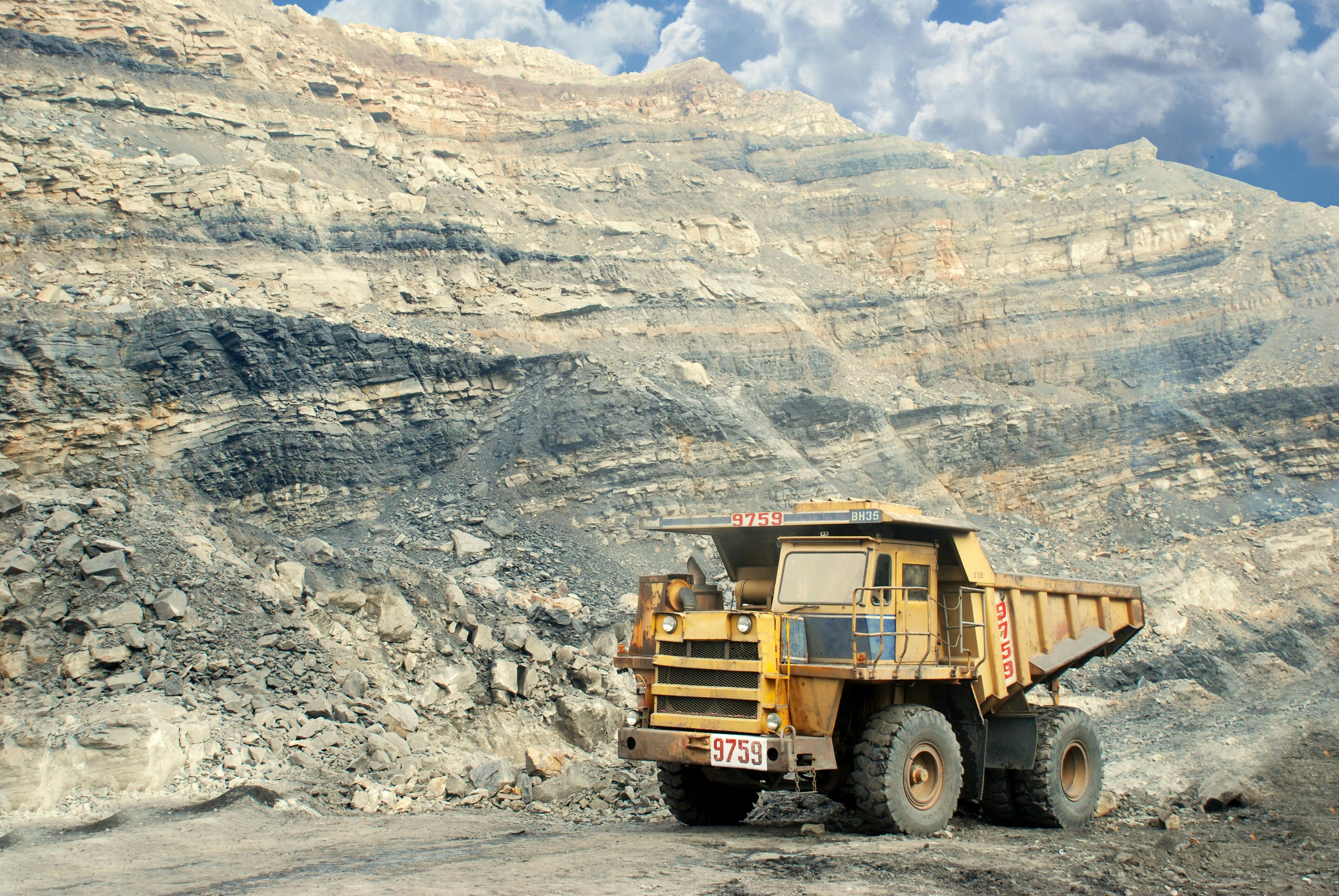 Open-pit mine with haul trucks and drilling equipment.