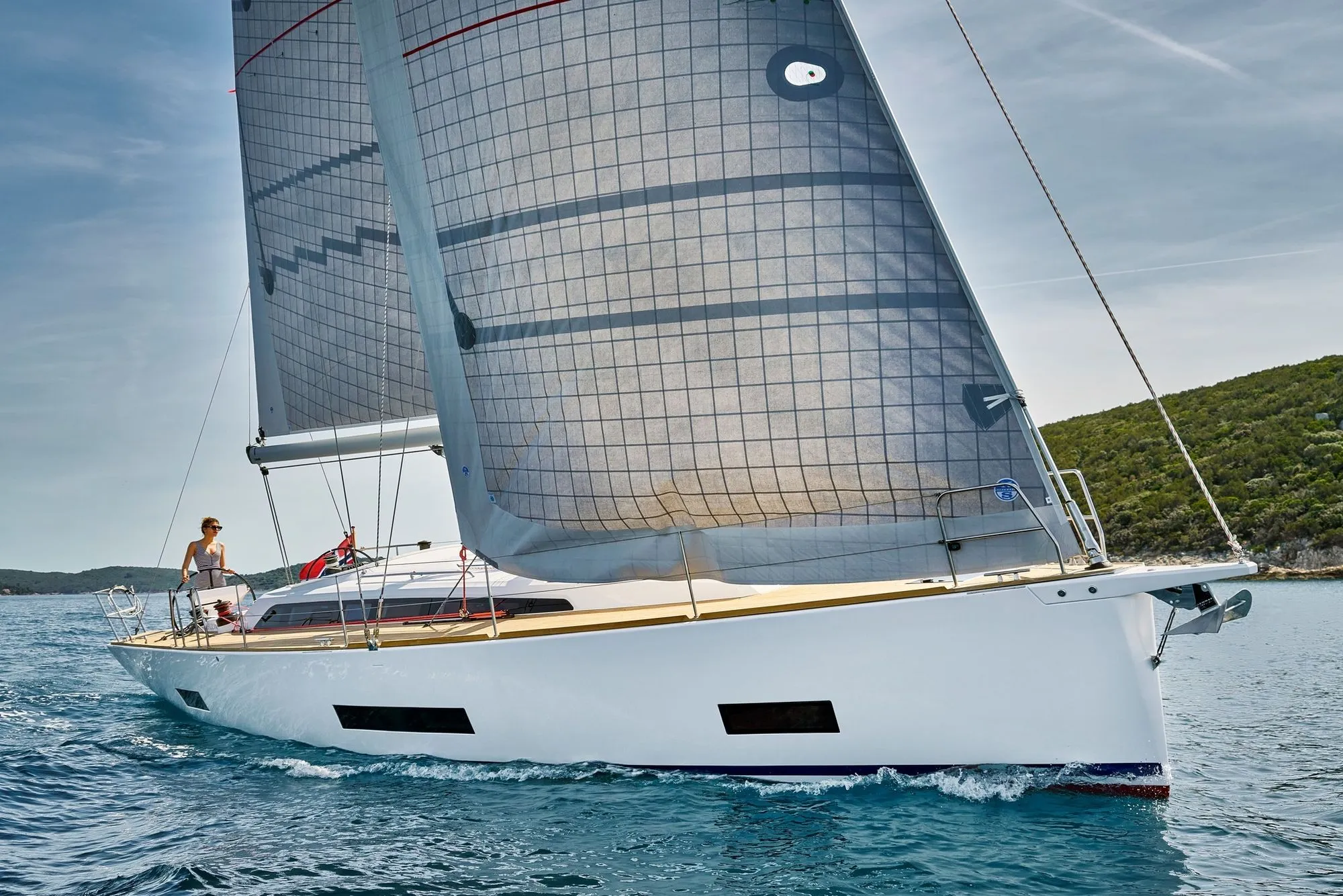 A Solano built Yacht sailing in the ocean with blue skies and choppy water
