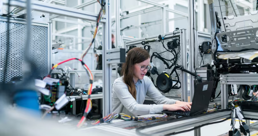 A woman works in an electrical assembly line