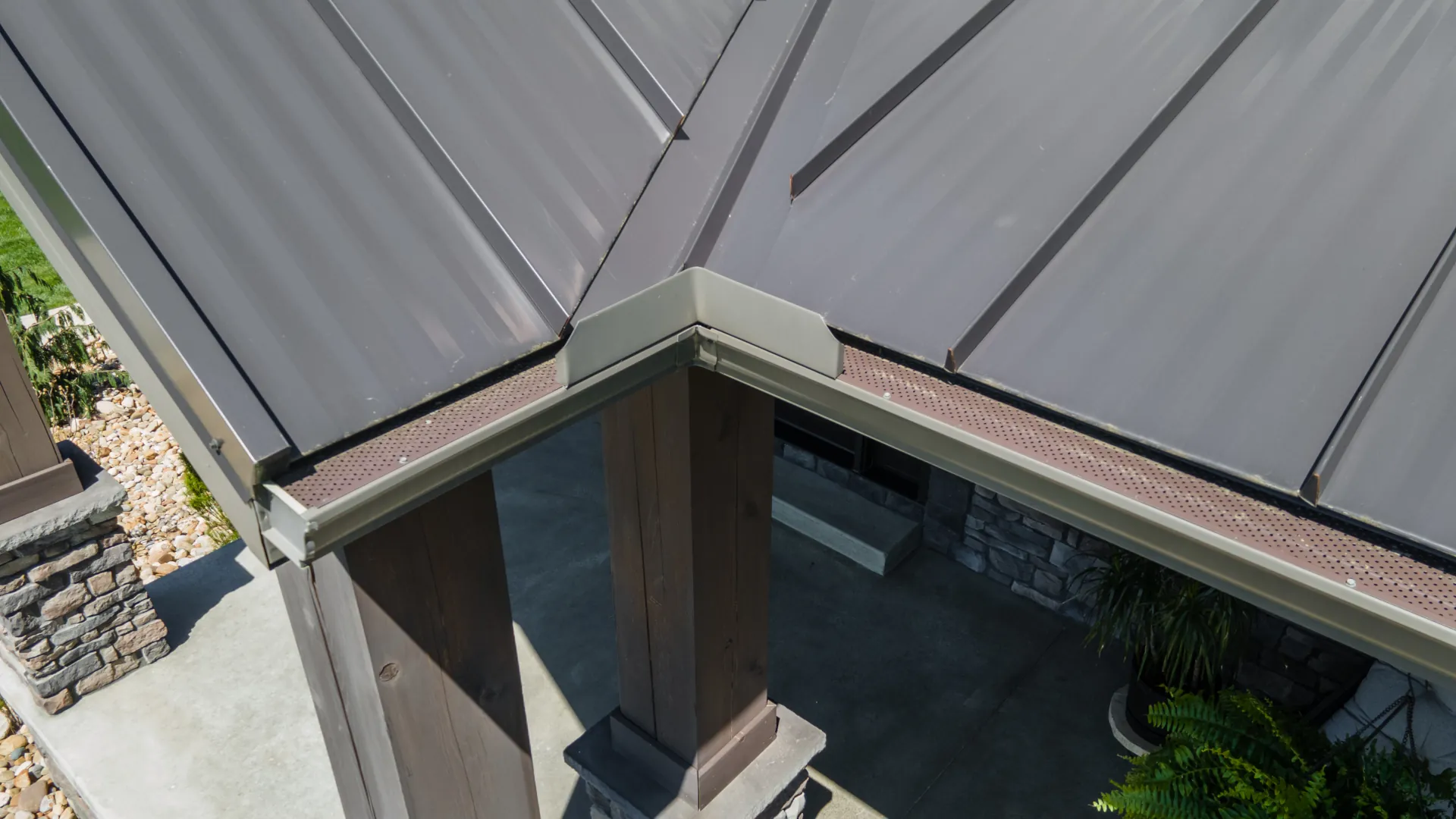 brown metal roof with gutter system and brown leaf guards