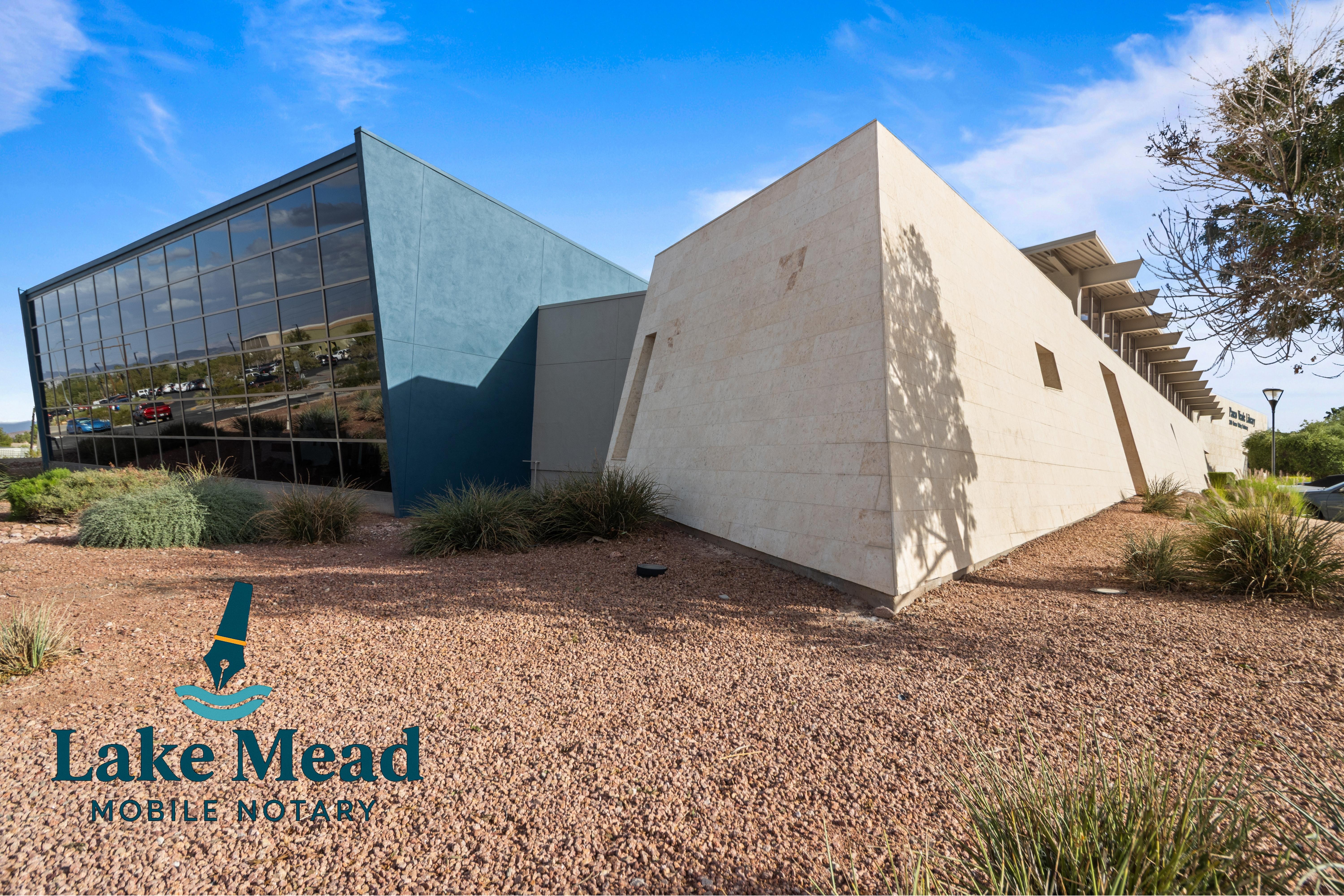 Architectural detail of modern civic building in Henderson; angular walls, desert plants, Lake Mead Mobile Notary logo visible.