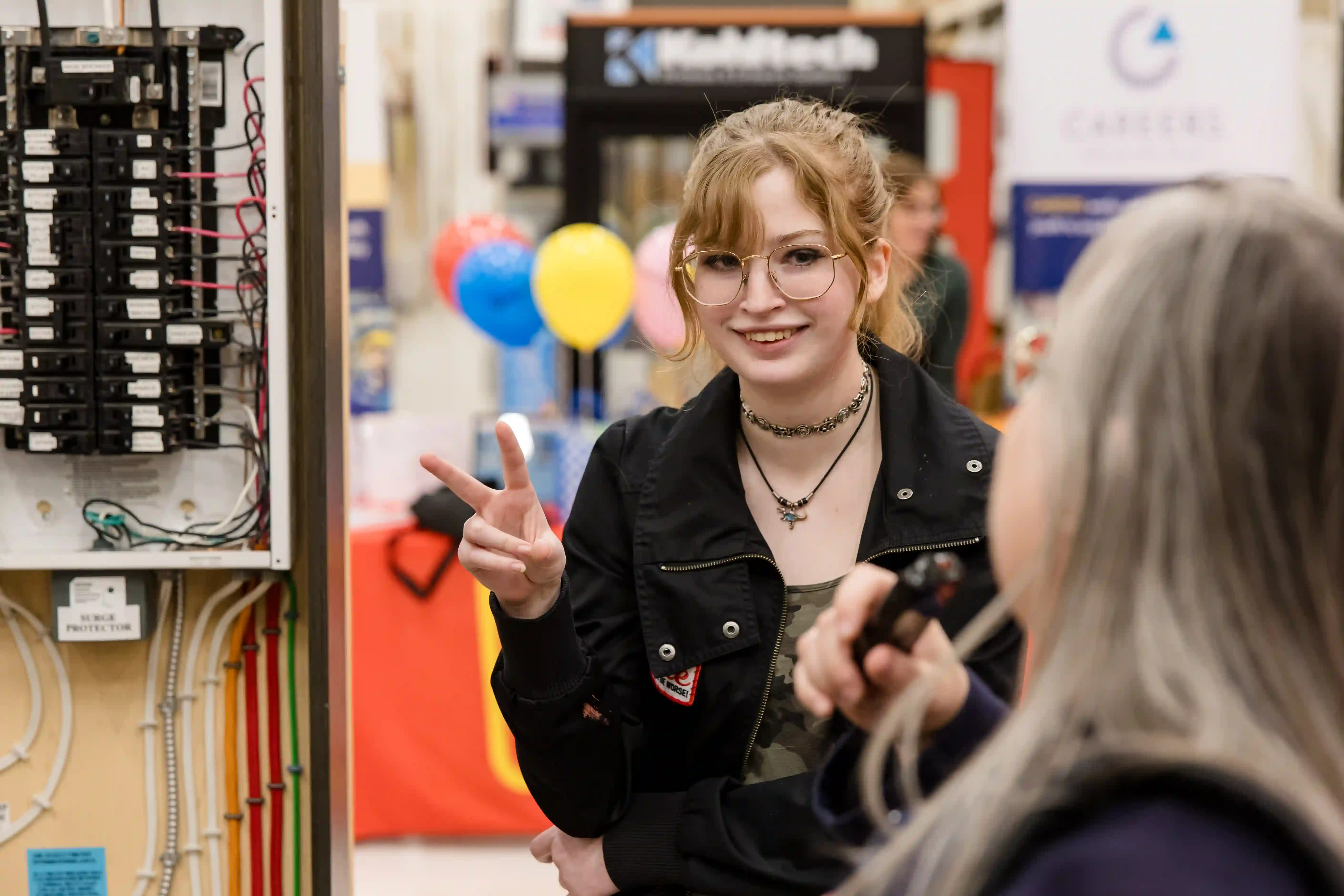 Young female showing peace sign in front electrical box