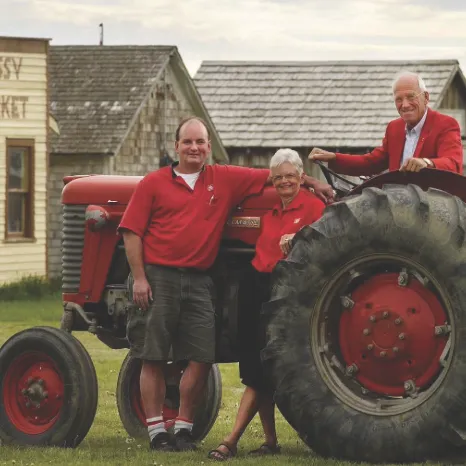 Mark, Roelof and Fern Heinen posing in front of a tractor