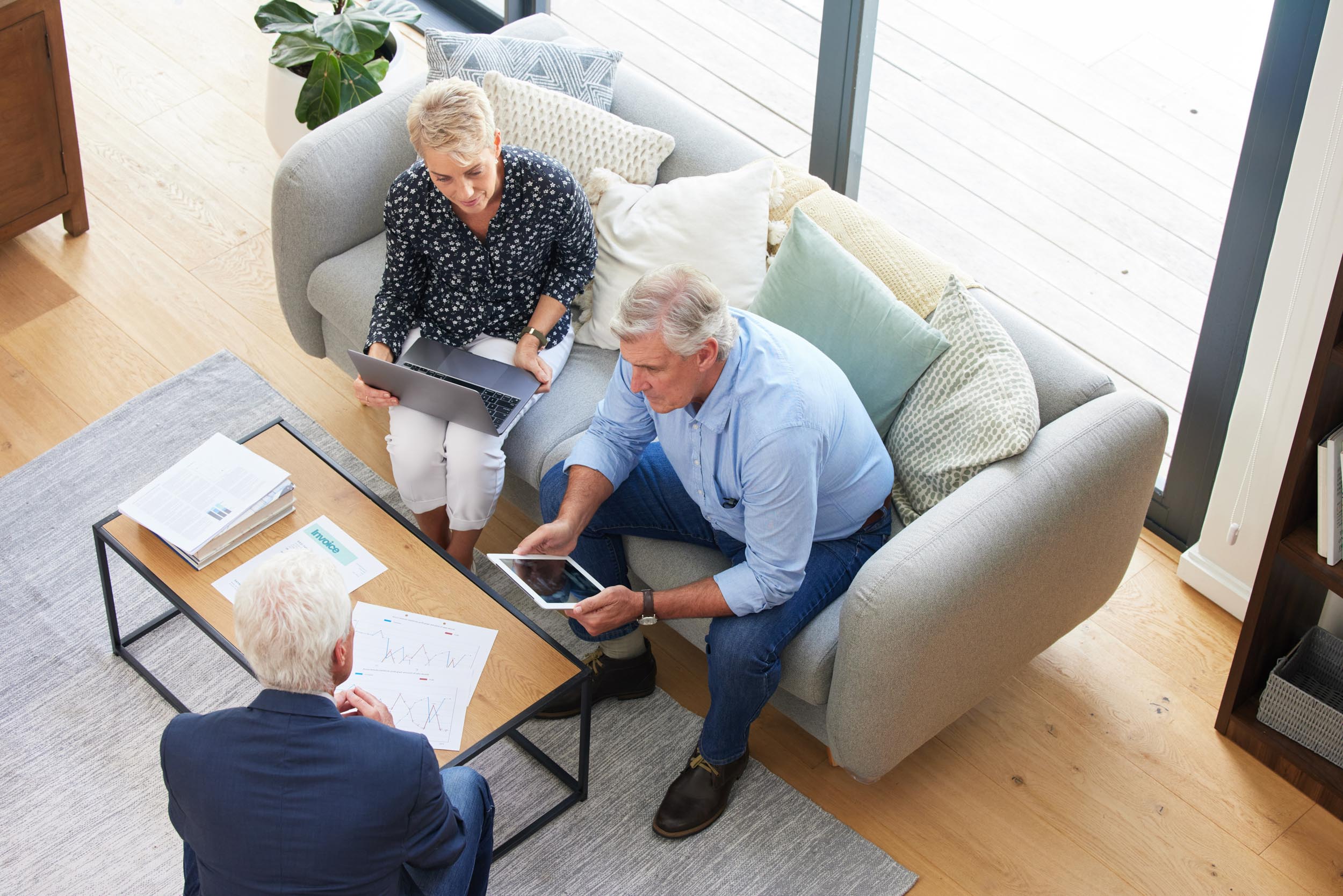 An aerial view of the same couple having a meeting with their accountant.