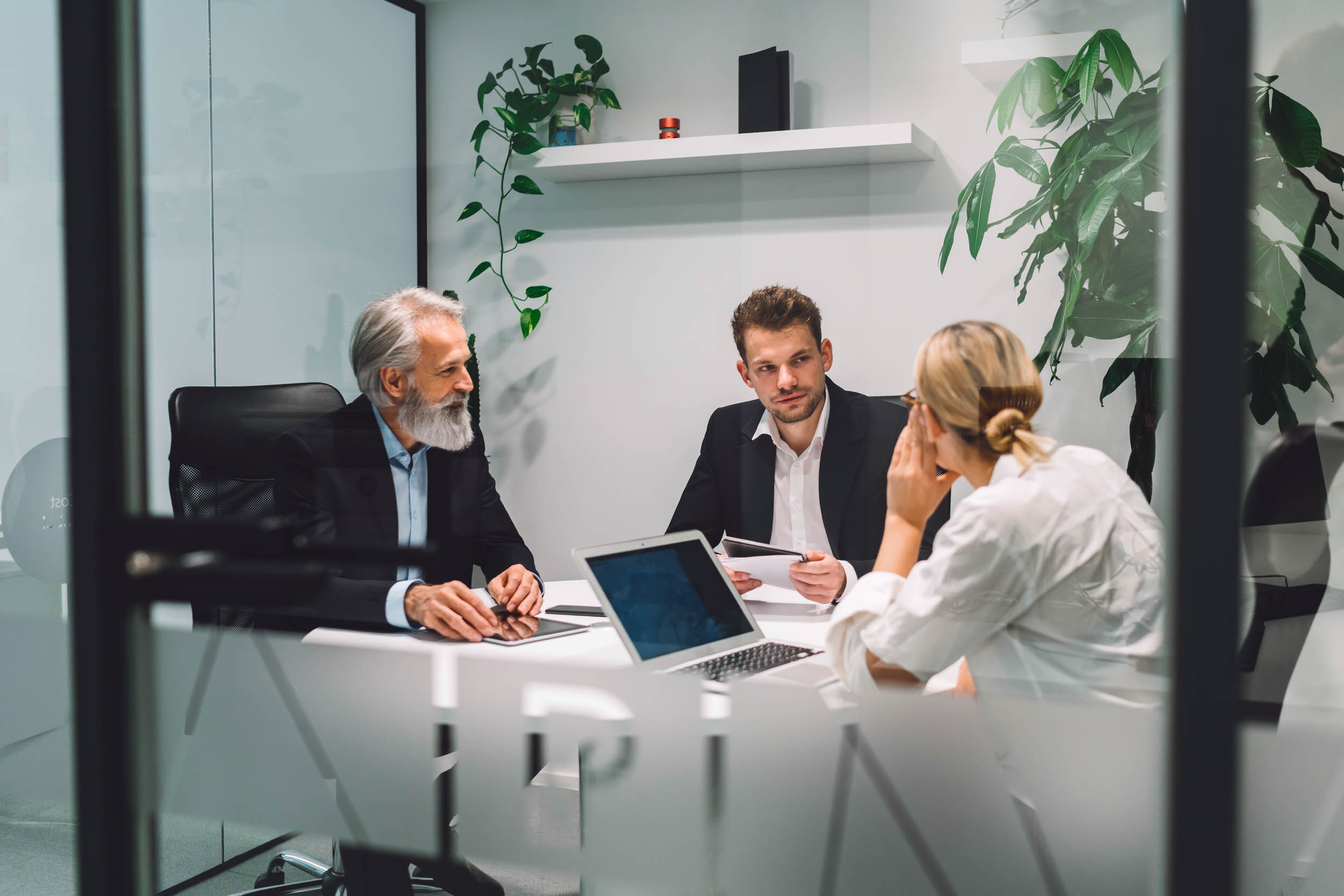 Office meeting taking place in a glass meeting room.
