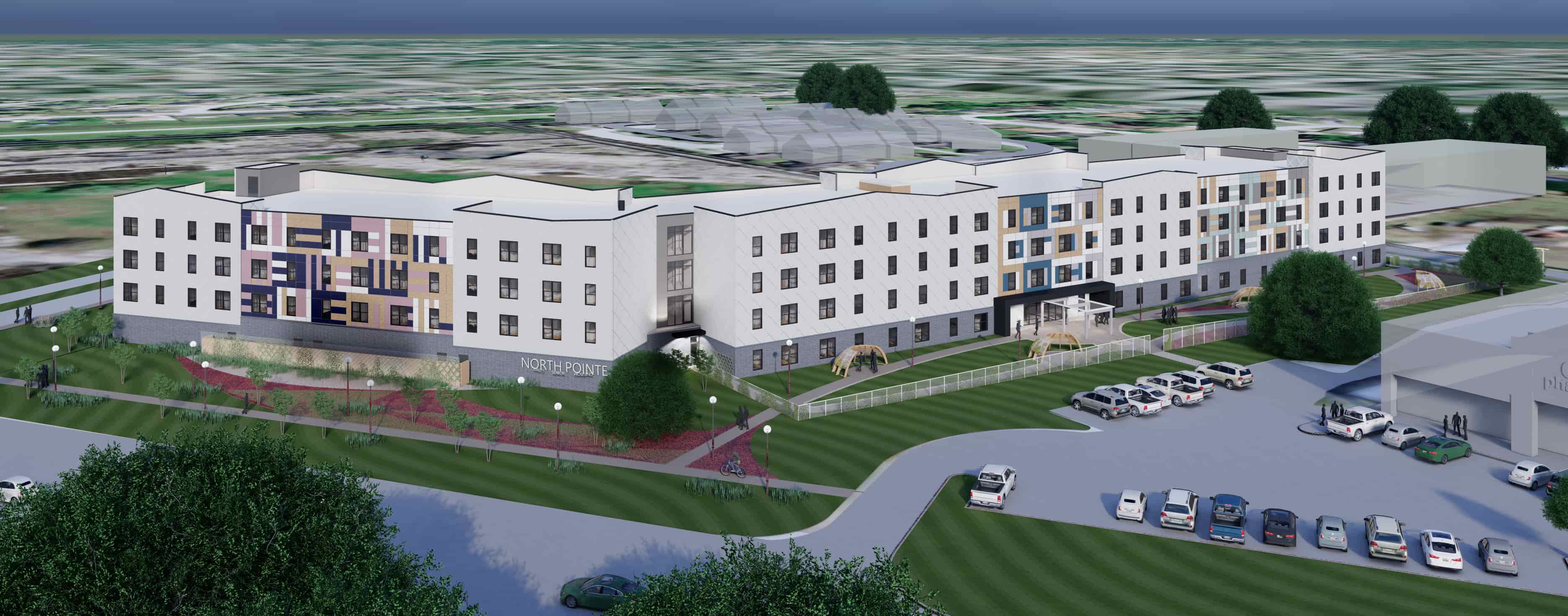 A modern, vibrant apartment community with colorful façades, green space, and family-friendly outdoor amenities.
