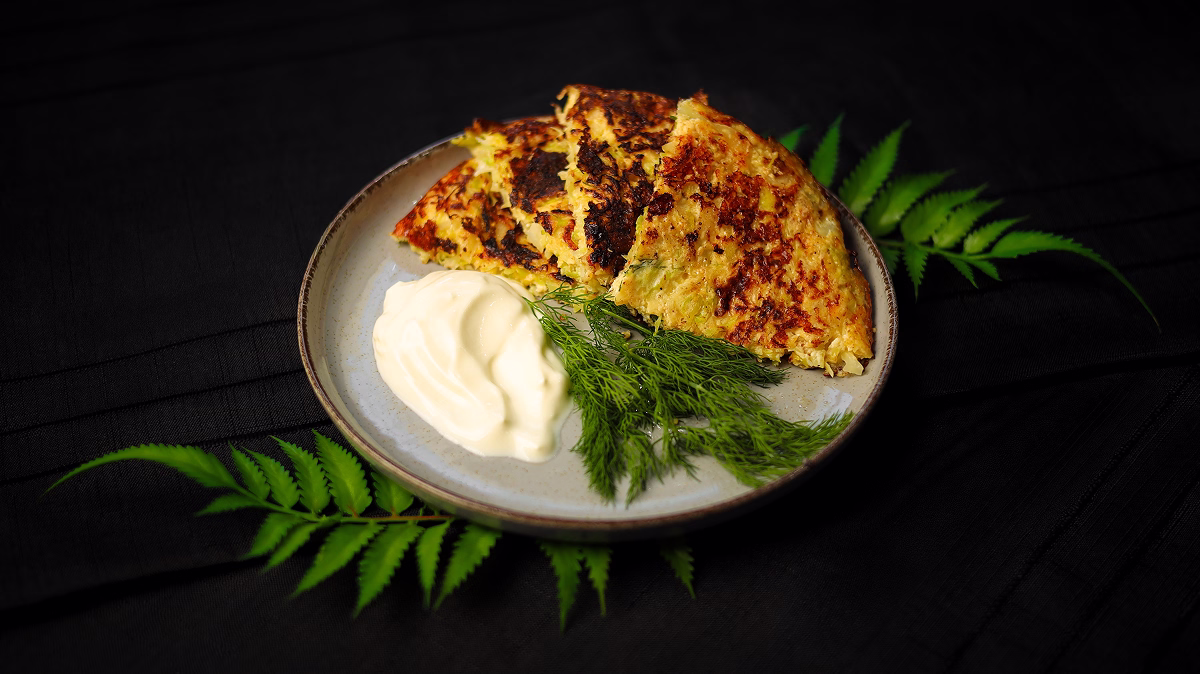 Plăcintă keto cu varză și cașcaval servită cu smântână