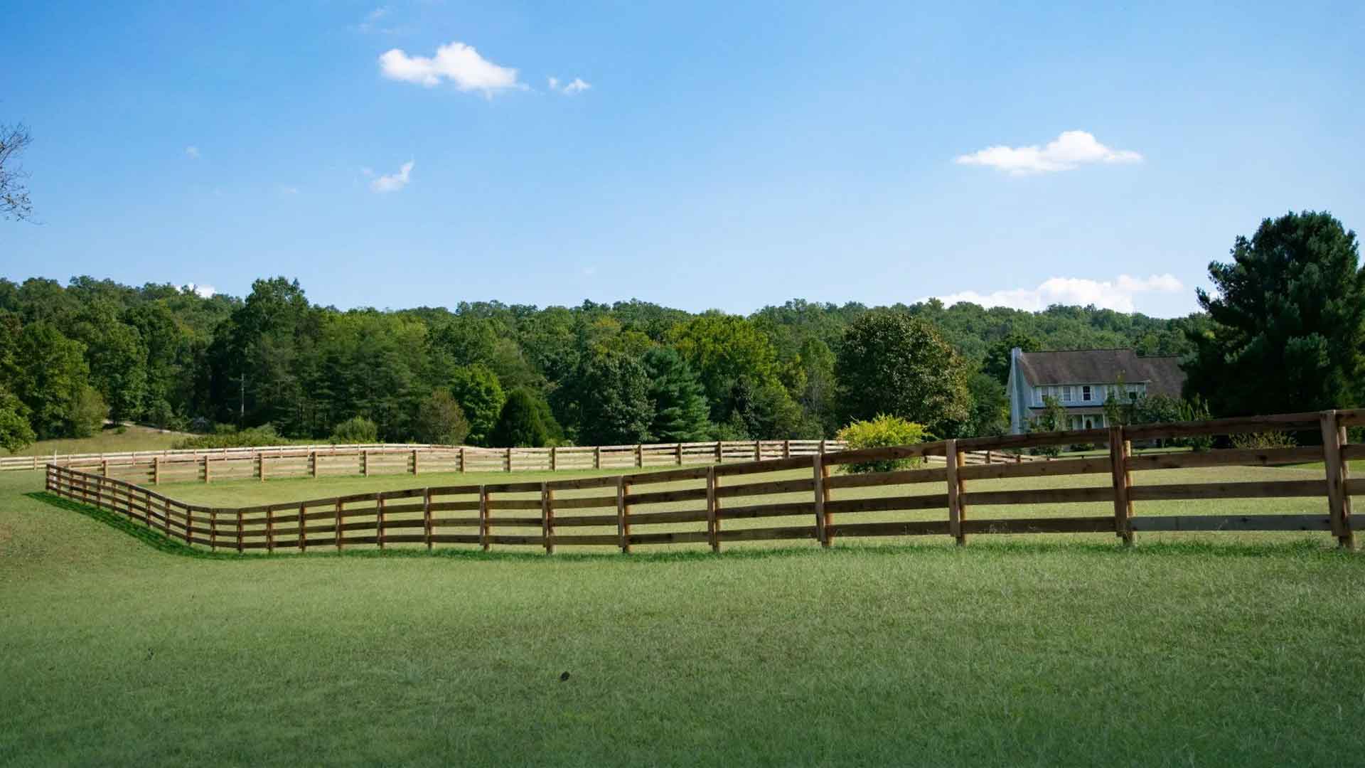 Four-board wood livestock fence enclosing a pasture on an East Tennessee farm, built by Loudon County Fence