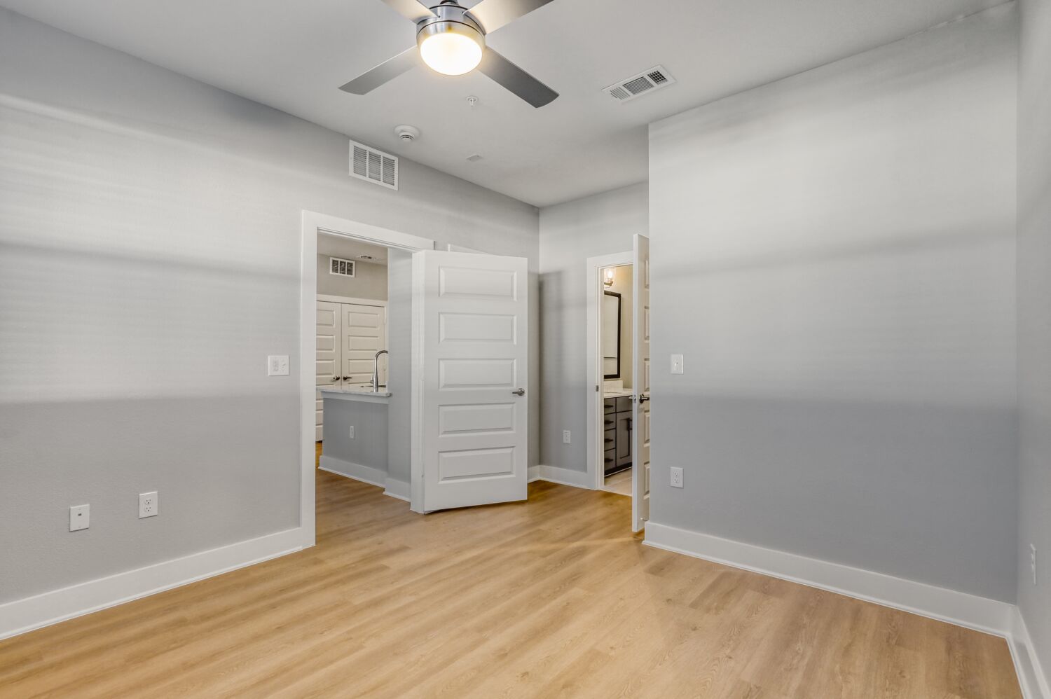 unfurnished bedroom with view of door and ceiling fan