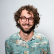 A man with glasses and a beard is smiling.