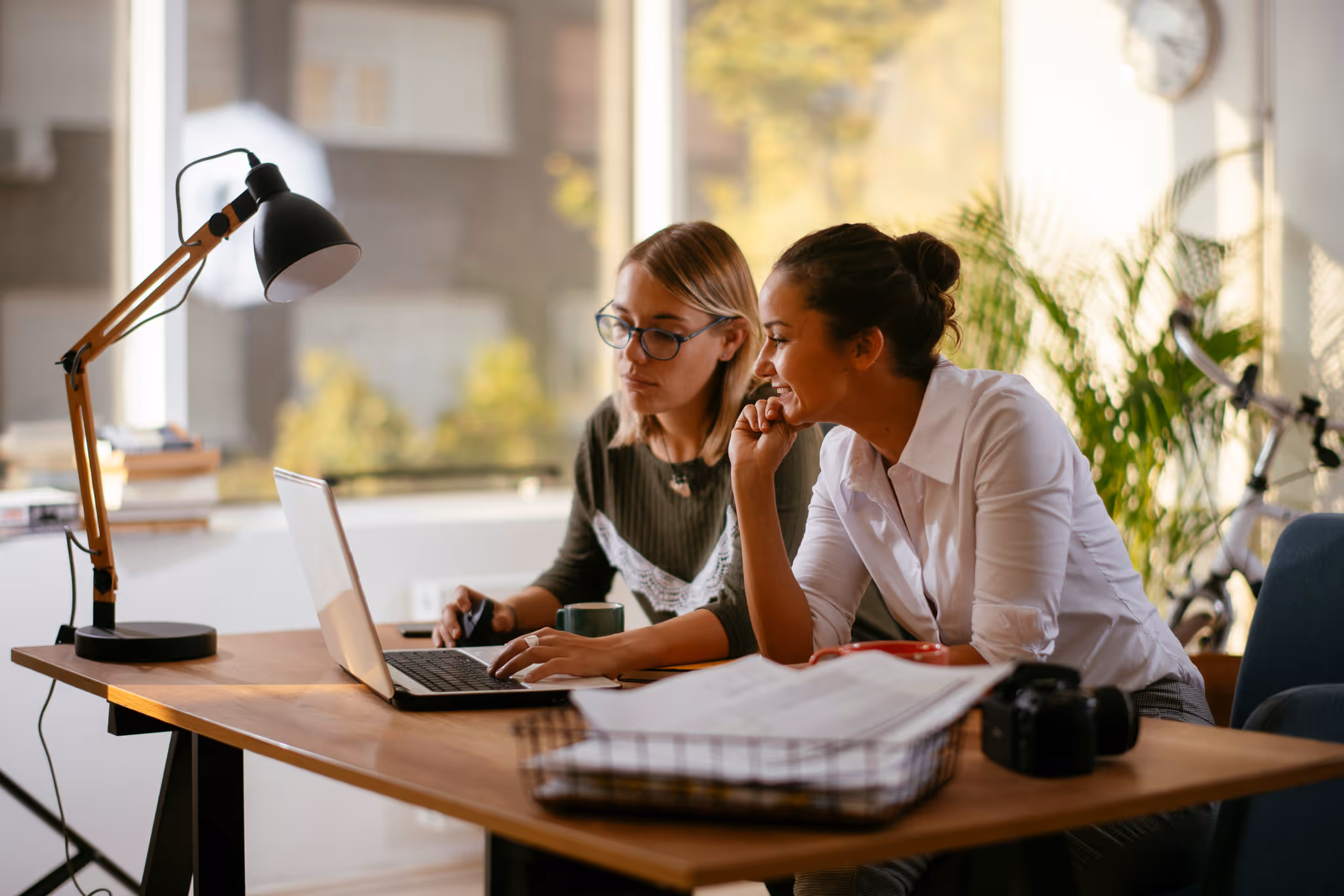 Two woman working on a computer at a desk