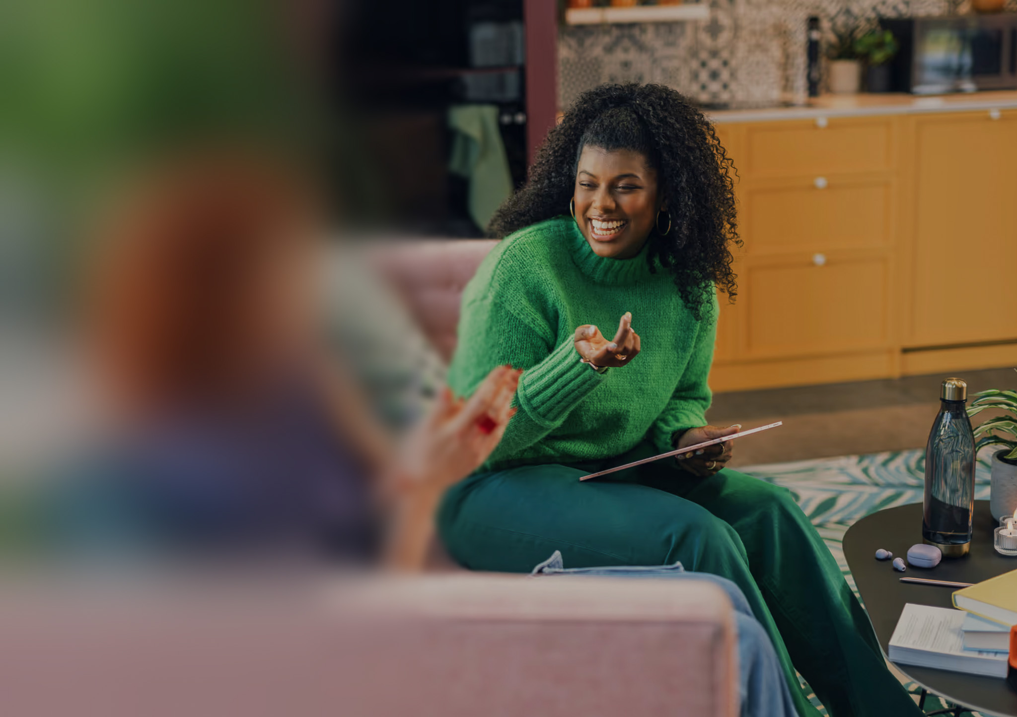 Two women talking on a couch with a blur effect