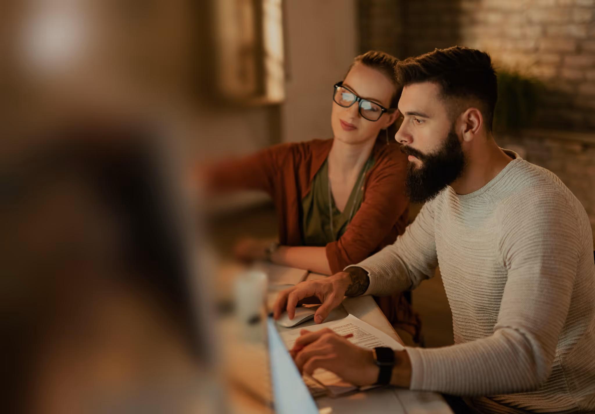 Blur effect overlaid on two people working on their computer in an office