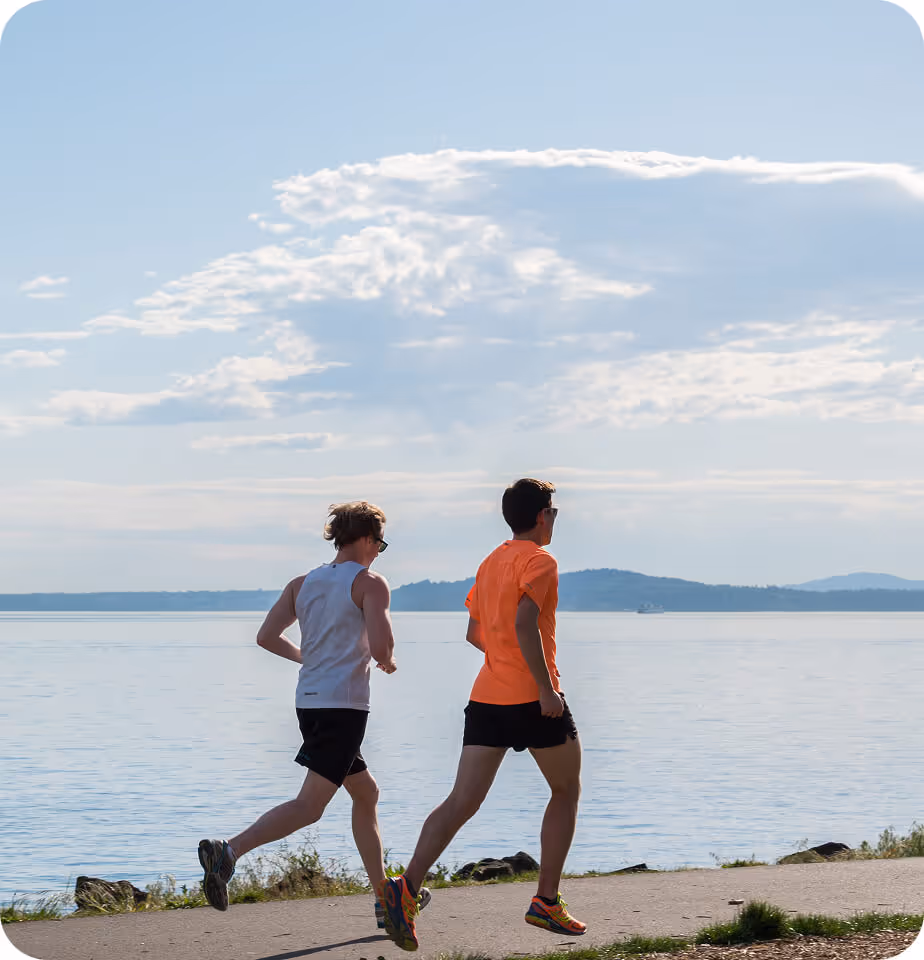 runners jogging along path near water - running pt services
