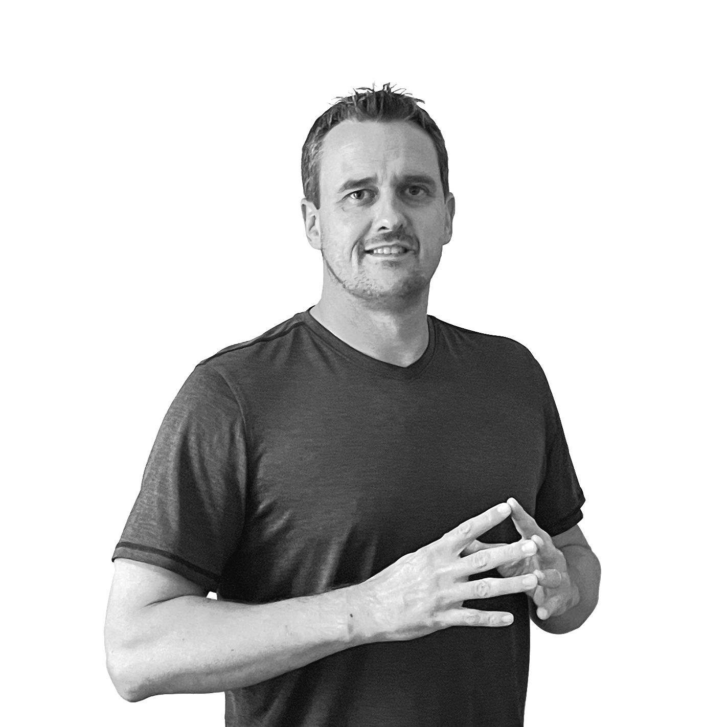 Man in a dark t-shirt smiling and holding his hands together near his chest.