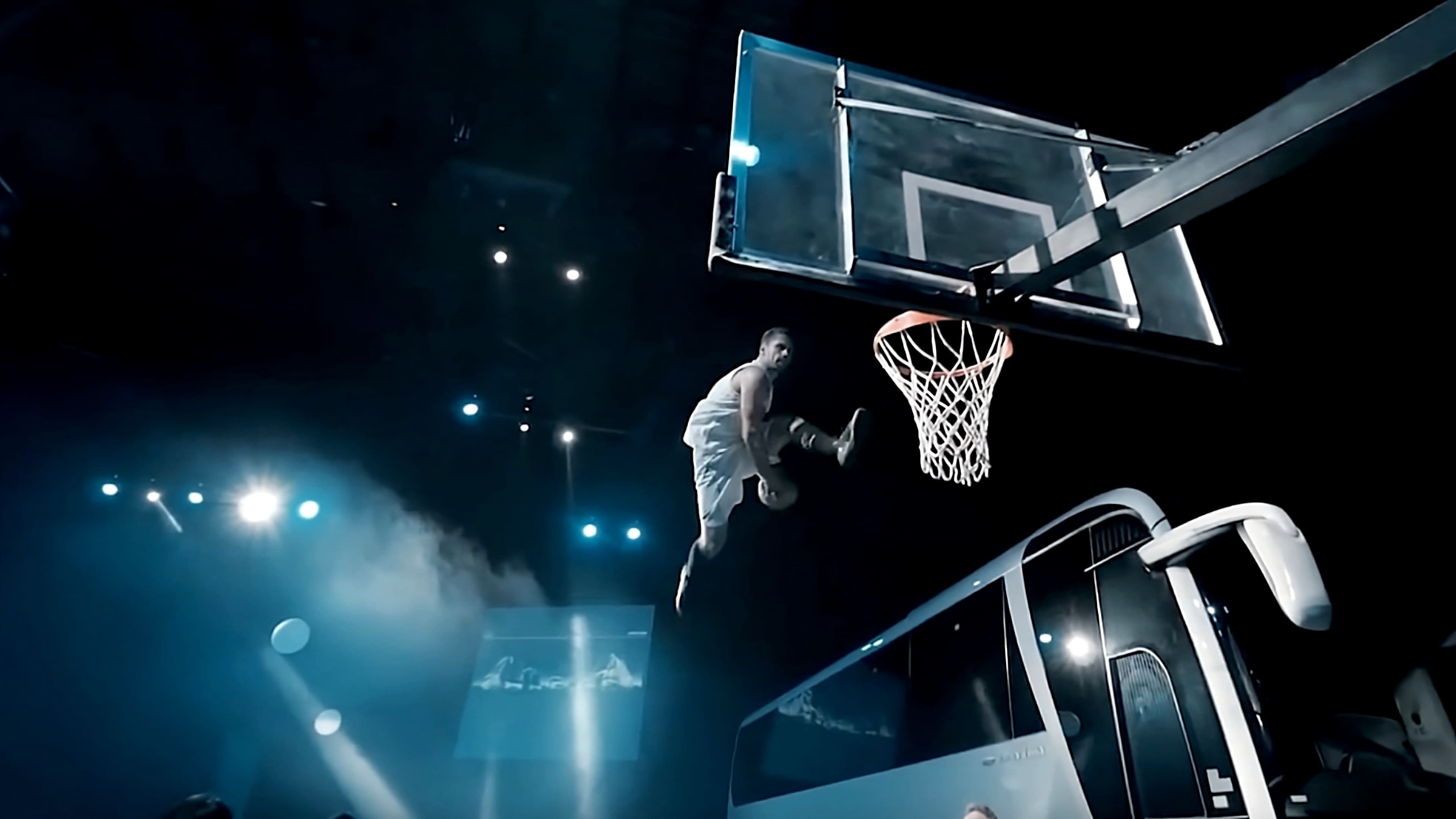 Basketballspieler in weißem Trikot springt hoch, um einen Dunk durch den Korb zu machen, mit einem Bus im Hintergrund und Bühnenbeleuchtung.