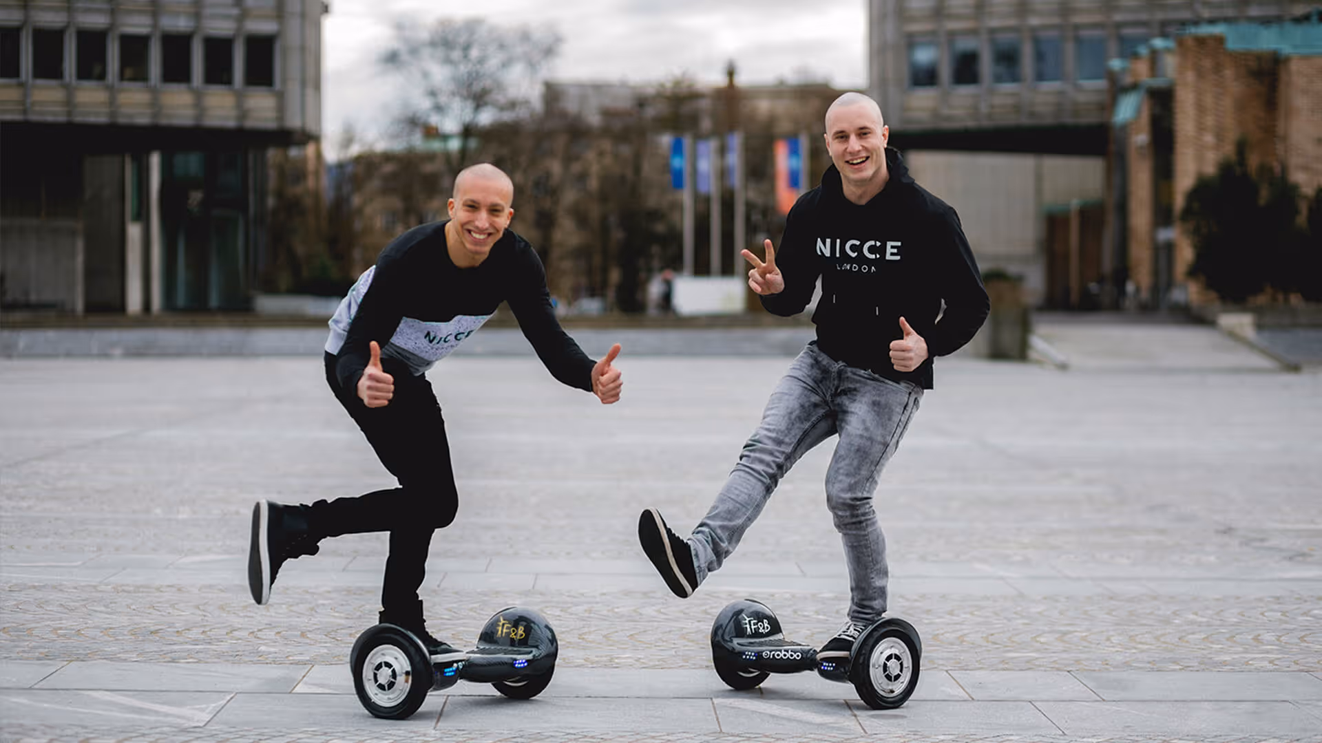 zwei Künstler mit Hoverboard schauen in die Kamera