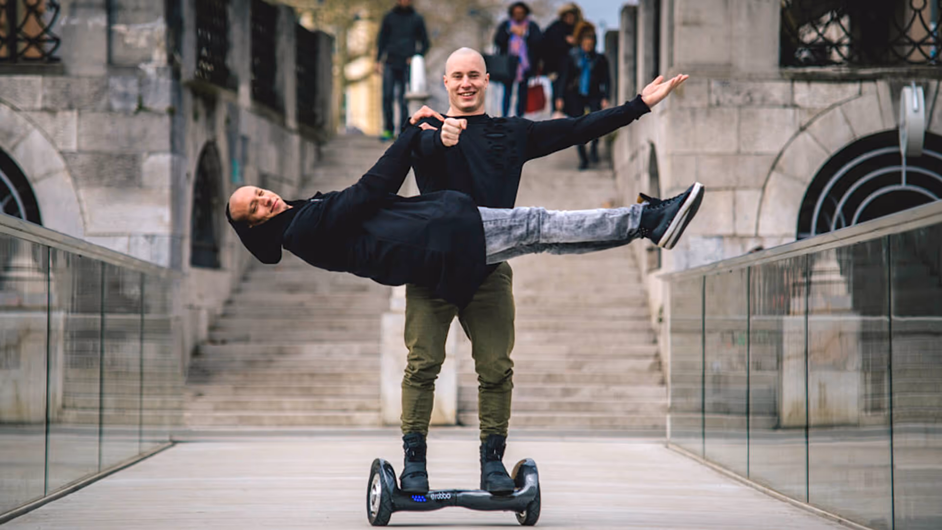 Zwei Künstler auf einem Hoverboard posieren zur Kamera