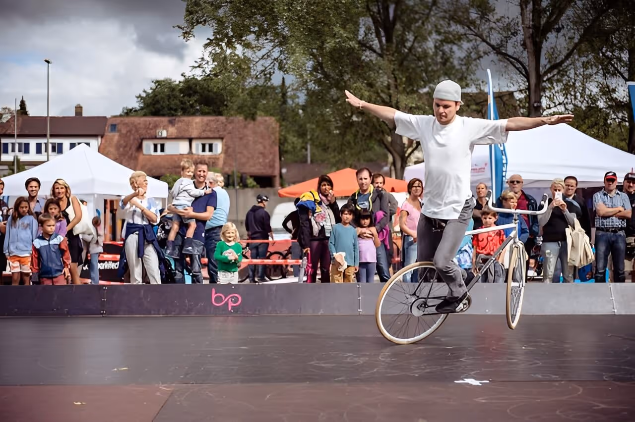 Showtrick von einem Kunstradfahrer bei einem sommerfest