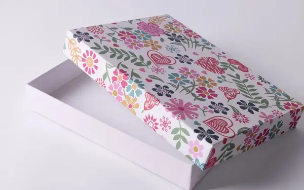 Open rectangular box with a lid decorated in colorful floral and heart patterns.