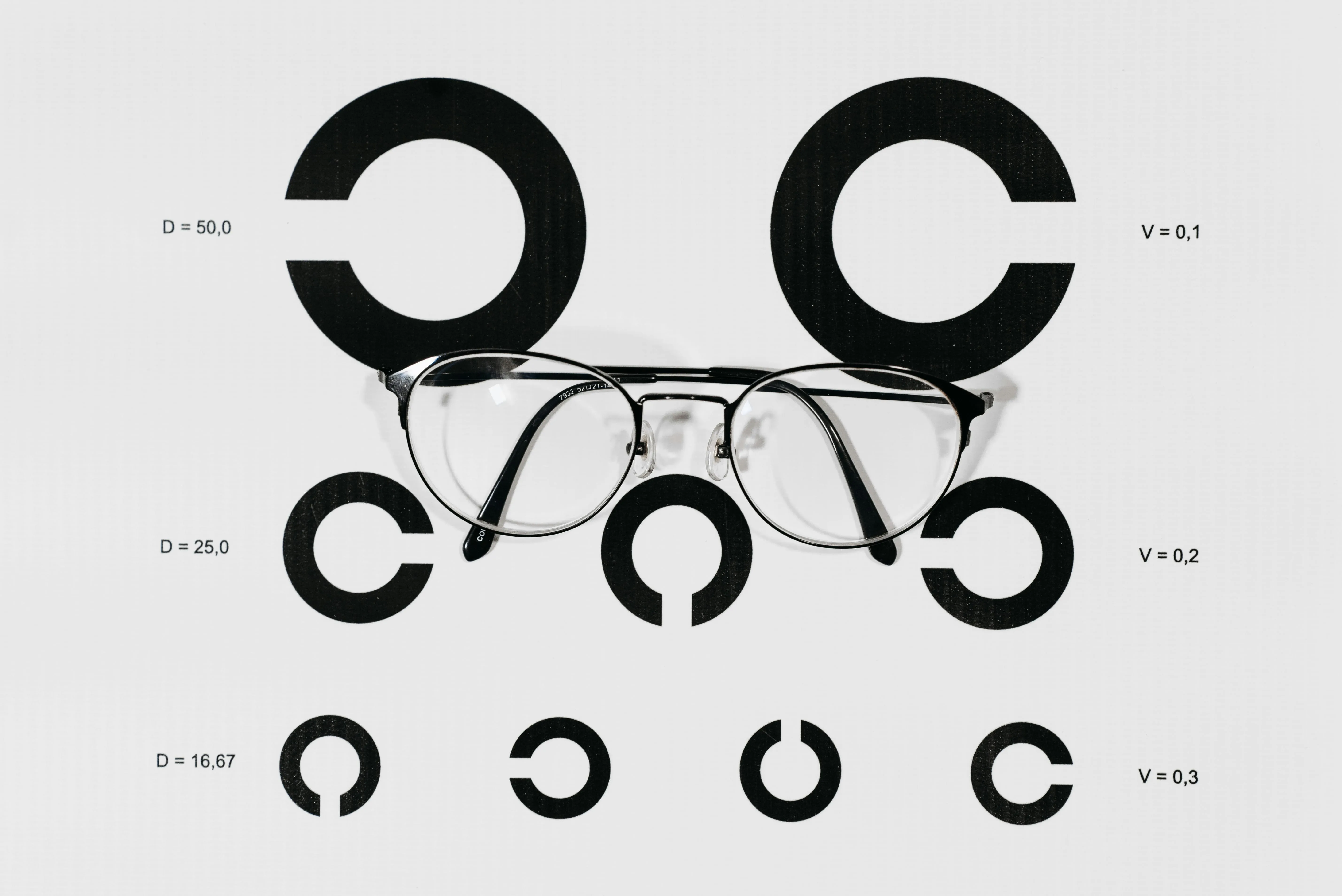 Eyeglasses on black and white circular diagram with measurement annotations