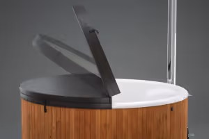 Wooden hot tub with a partially open black insulated cover against a gray background.