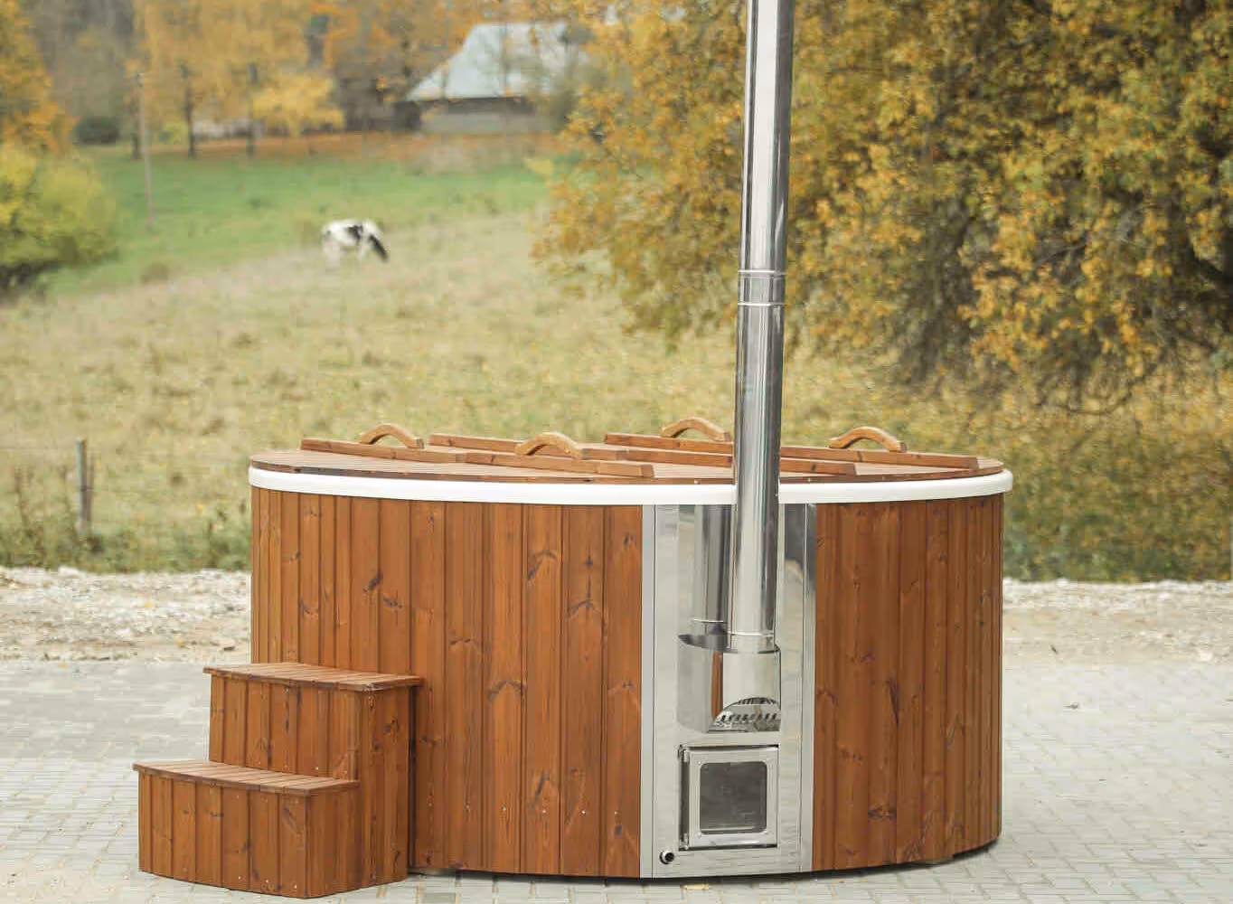 A wood-fired hot tub installed on concrete slabs or pavement.