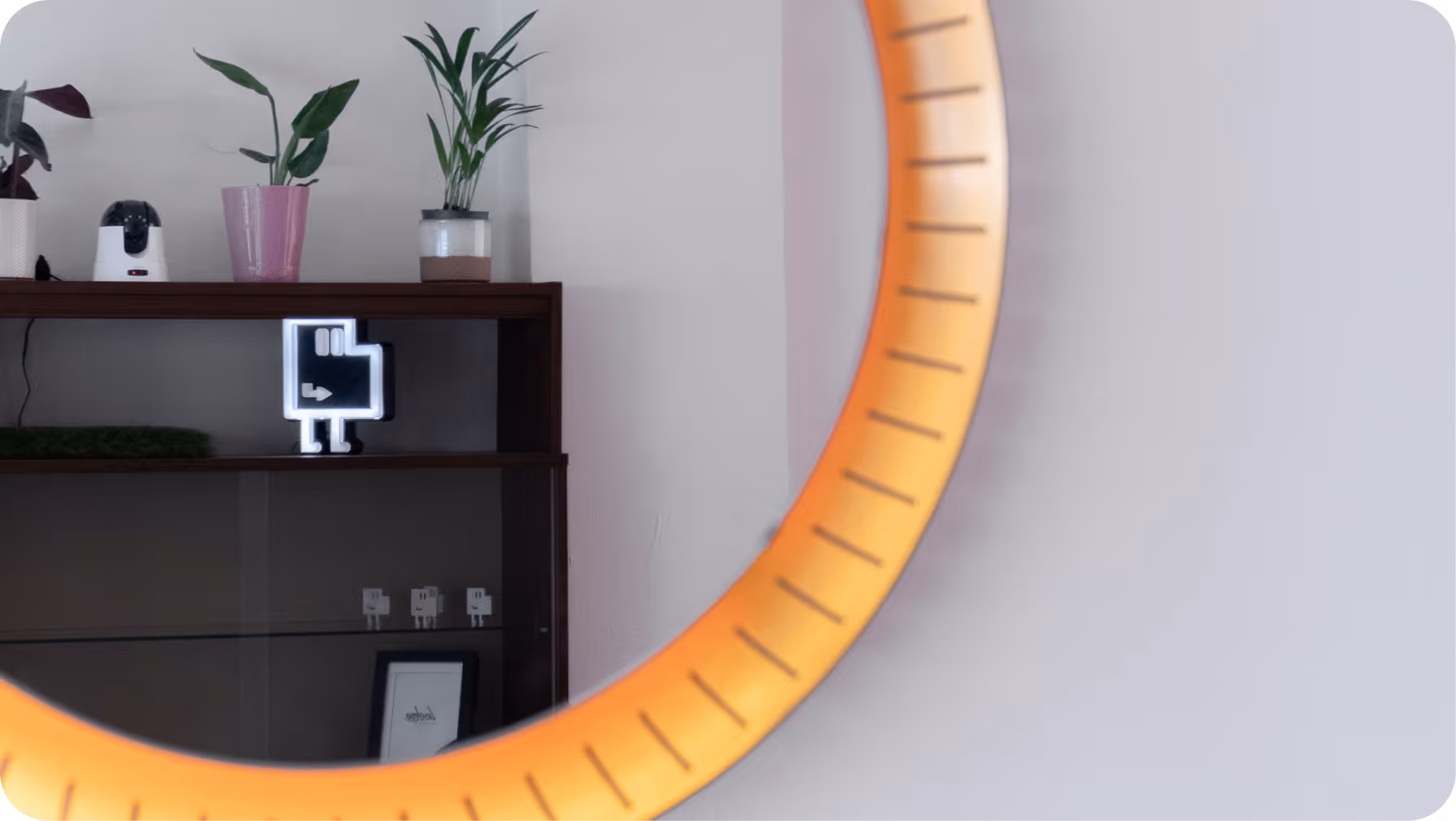 Regal mit Pflanzen und leuchtender pixelartiger Figur vor weißer Wand.