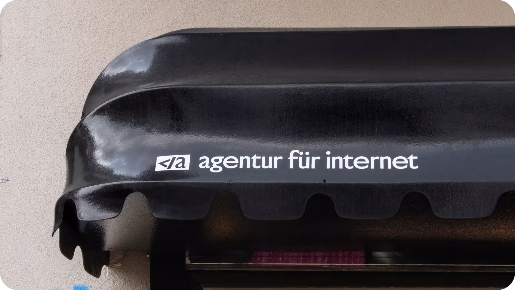 Schwarzes Sonnensegel mit weißer Aufschrift: agentur für internet.