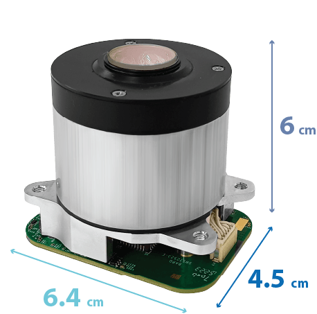 Compact cylindrical electronic sensor mounted on a green circuit board with dimensions 6.4 cm by 4.5 cm by 6 cm.