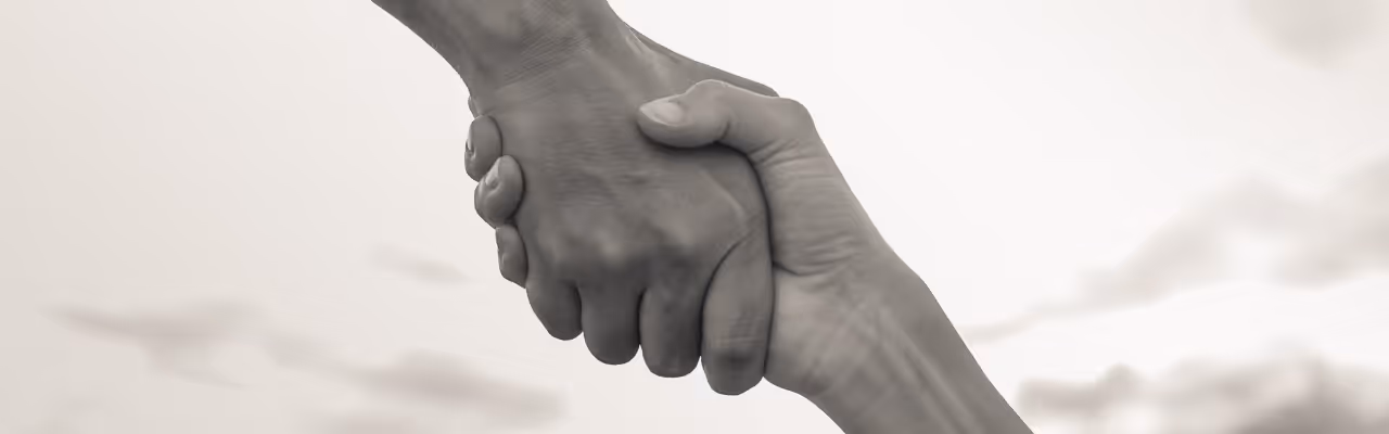 Une main tenant fermement l'autre en signe de soutien et d'entraide.