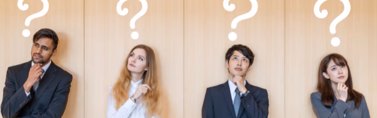 Quatre professionnels debout réfléchissant, chacun avec un point d'interrogation au-dessus de la tête.