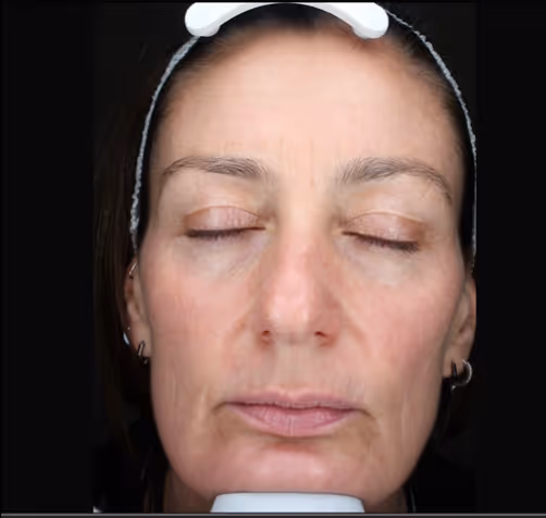 Close-up of a middle-aged woman's face with eyes closed, wearing a headband.