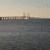 Profilbillede brugt i en anmeldelse, som viser en bro i horisonten over vandet ved solnedgang – billedet er landskabsorienteret og uden synlige personer.