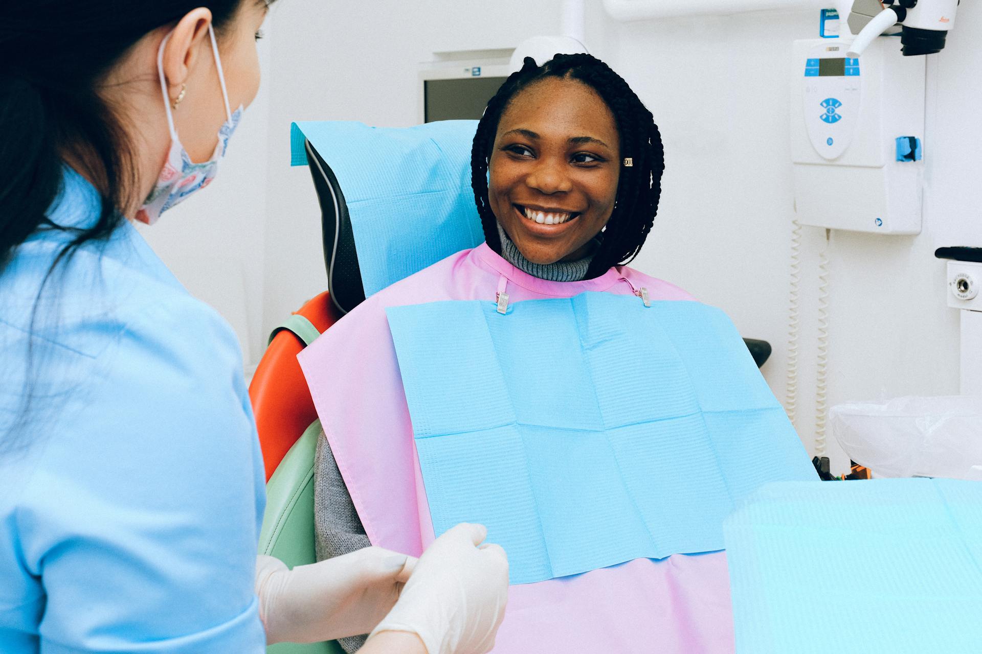 A woman in a dentist's chair smiling at the camera.