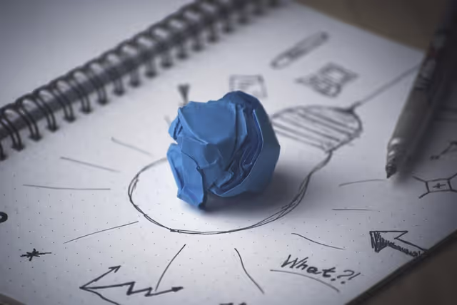 squeezed paper on top of a book with a drawing of a bulb to show idea