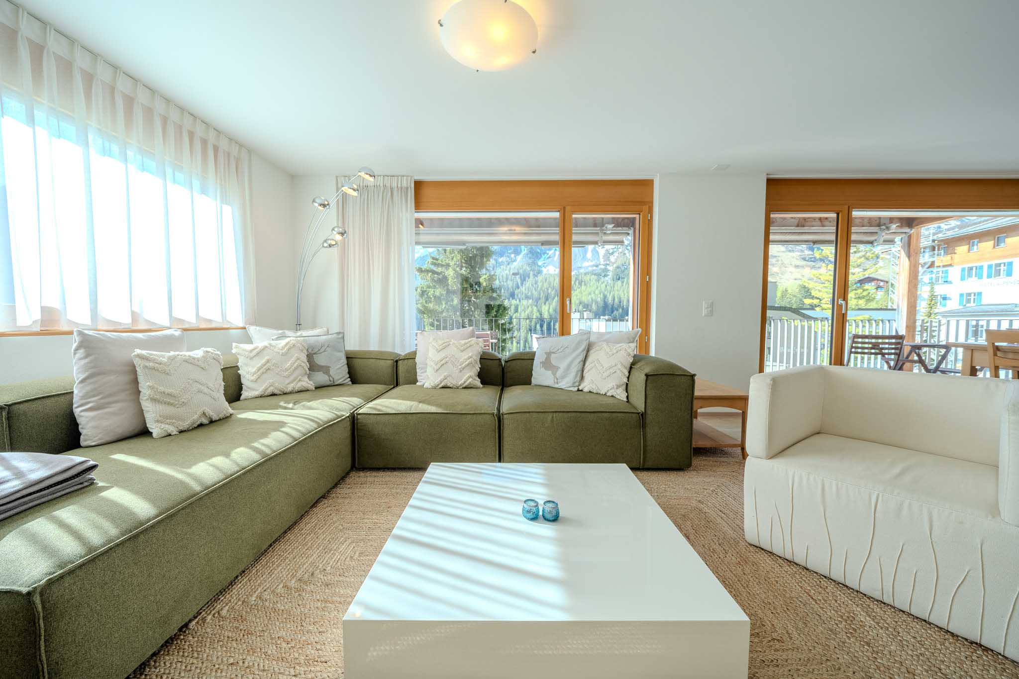Apartment Sunnaschy Heidi in Arosa. Picture of the living room with a nice green sofa.