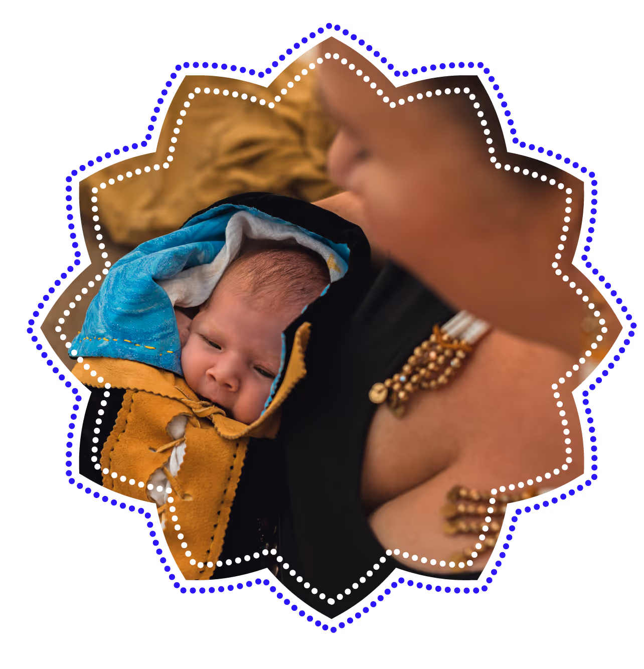 Newborn baby wrapped in a traditional indigenous moss bag held by a caregiver