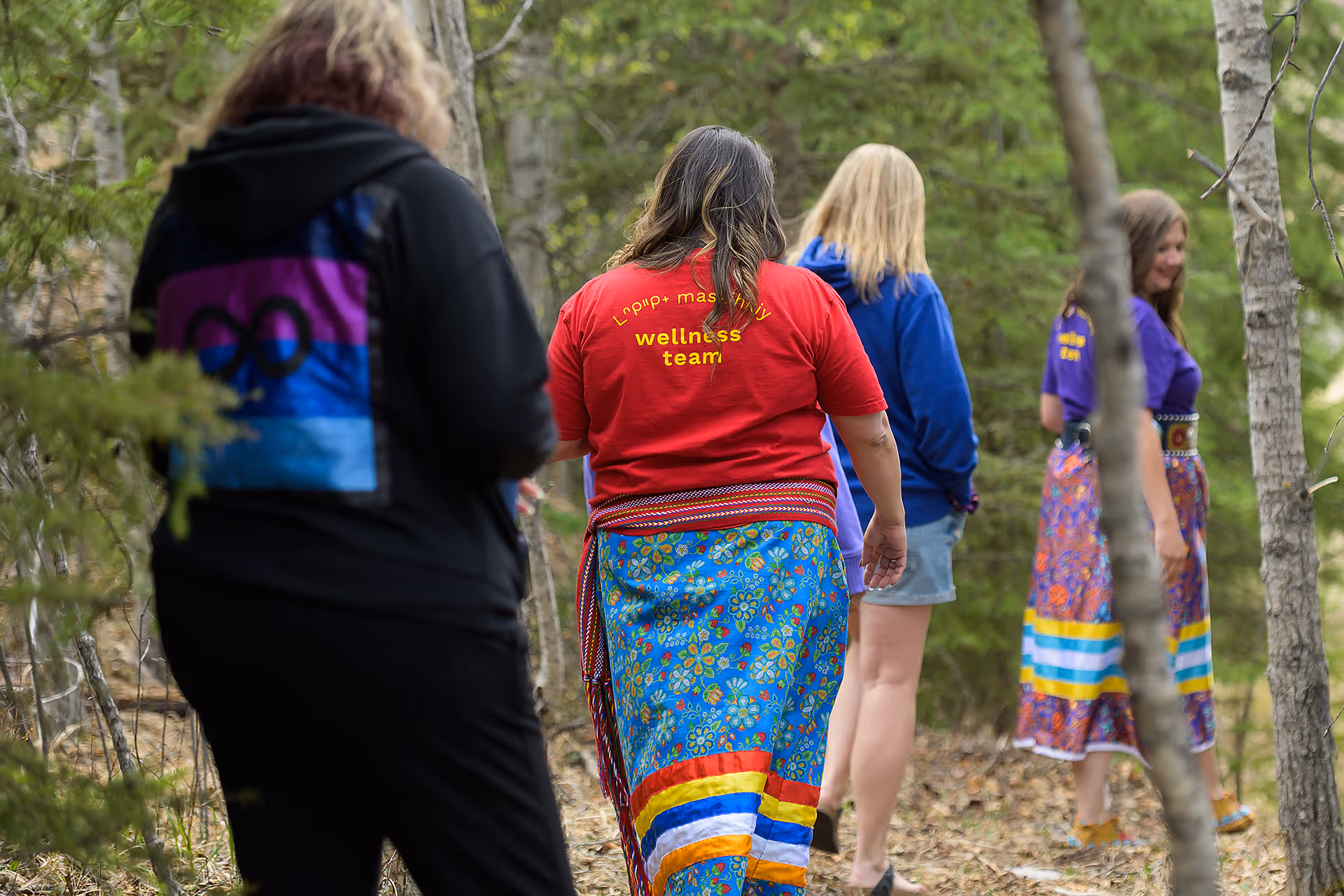 Participants walking together through a forest during an outdoor cultural wellness program