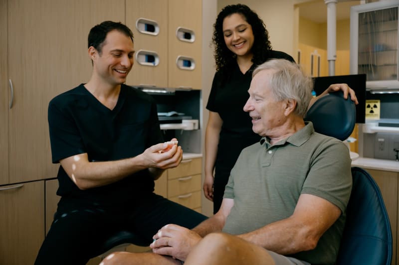 Dentist consulting with male patient, discussing treatment options in clinical setting