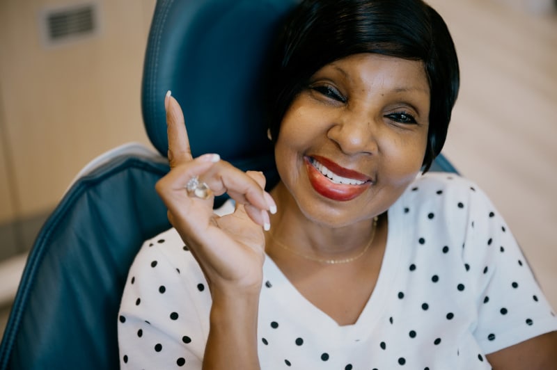 Smiling patient in clinical setting after successful treatment