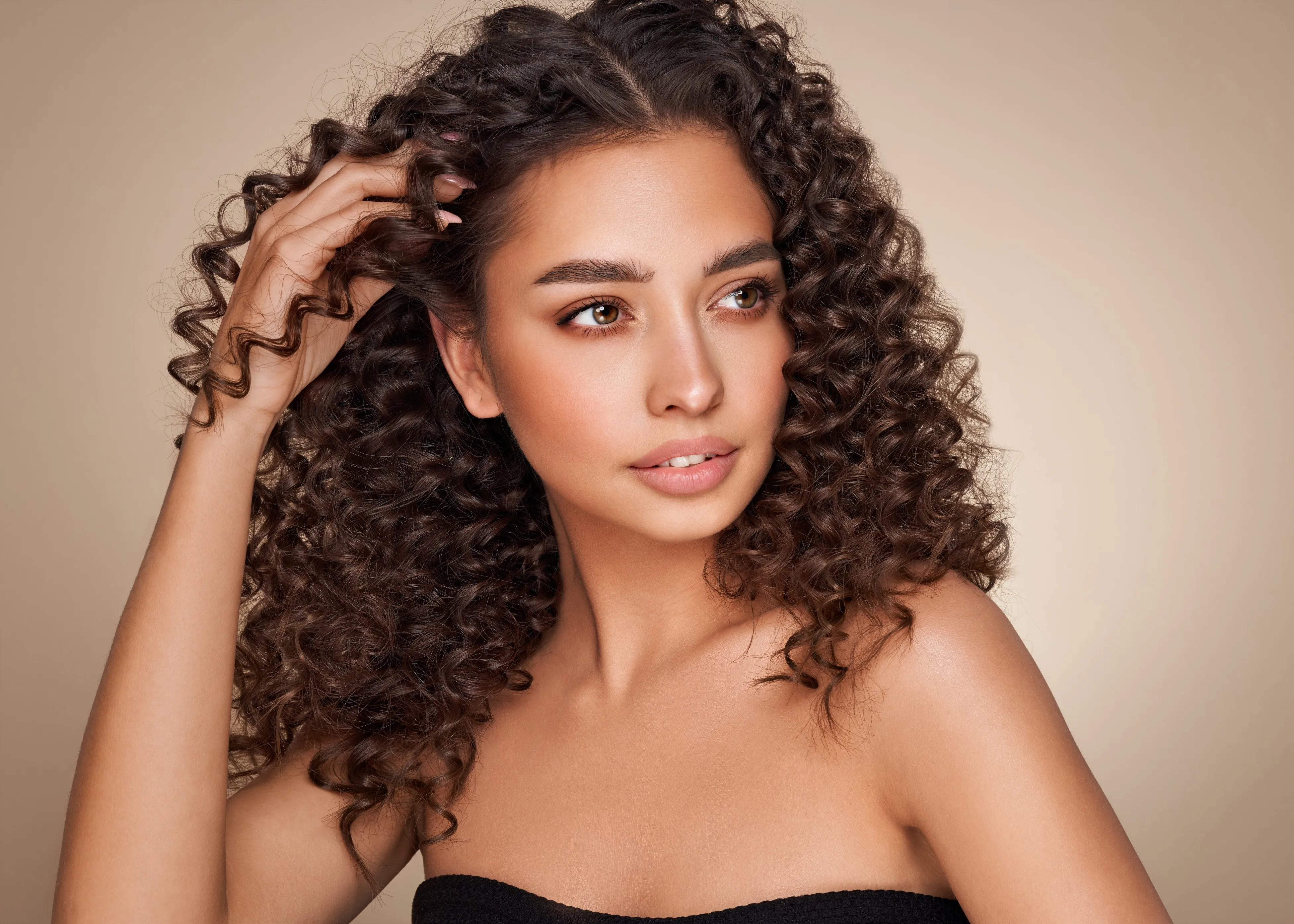 A woman with curly hair is posing for a picture.